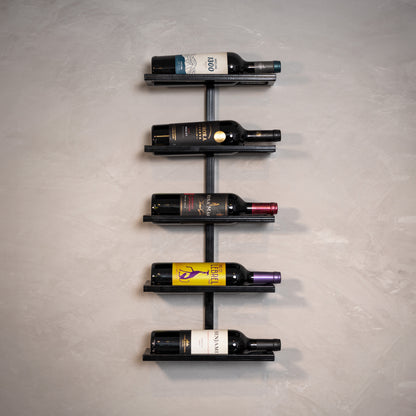 Estante de vinho moderna com garrafas coloridas em parede cinza, ideal para decoração sofisticada e organização.
