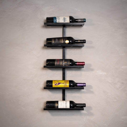 Estante de vinho moderna com garrafas coloridas em parede cinza, ideal para decoração sofisticada e organização.